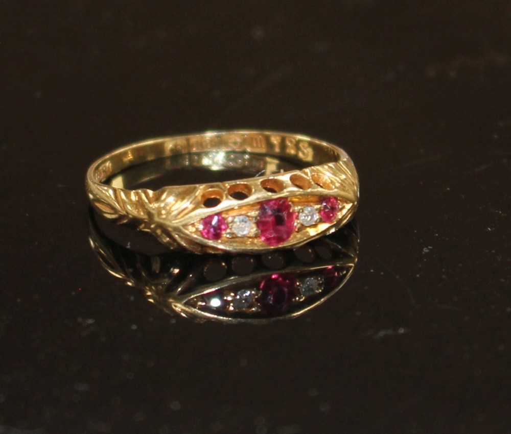 A George V 18ct gold, three stone ruby and two stone diamond set half hoop ring, size P, gross weight 1.9 grams.